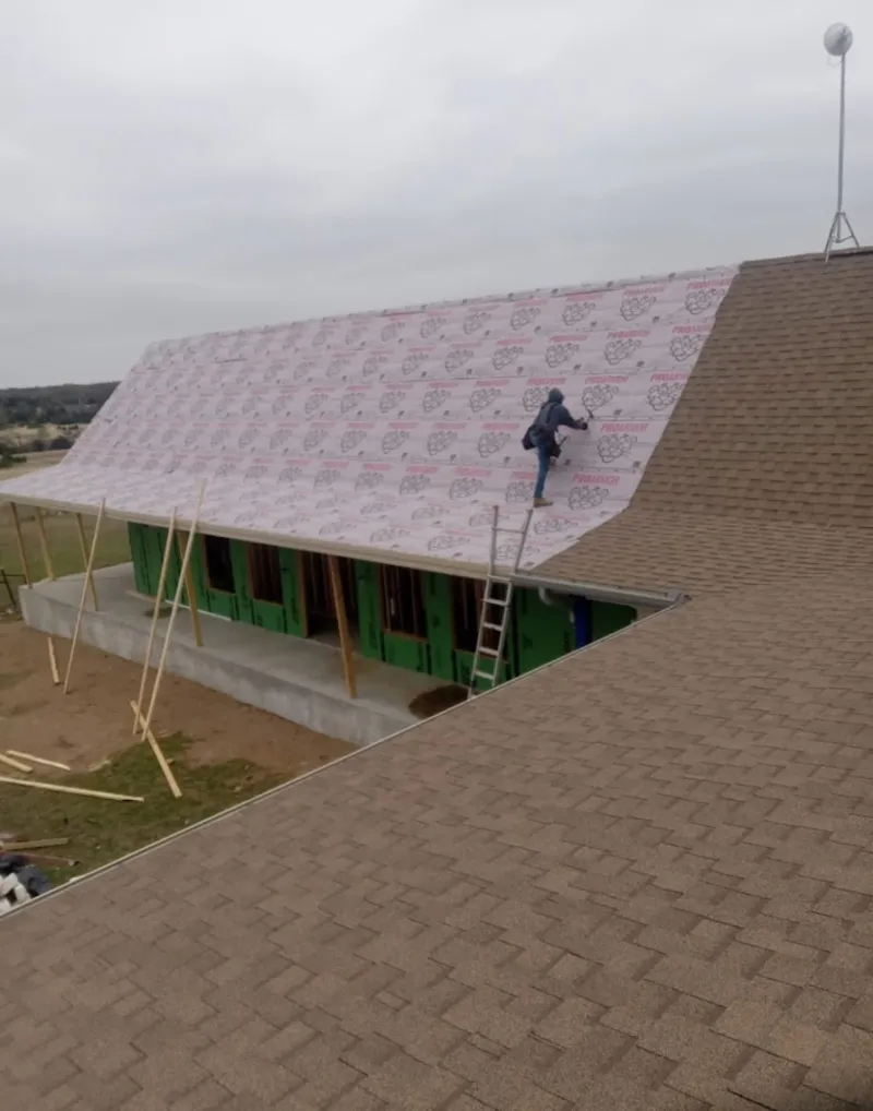 Worker preparing underlayment for a metal roof installation in Sierra Madre